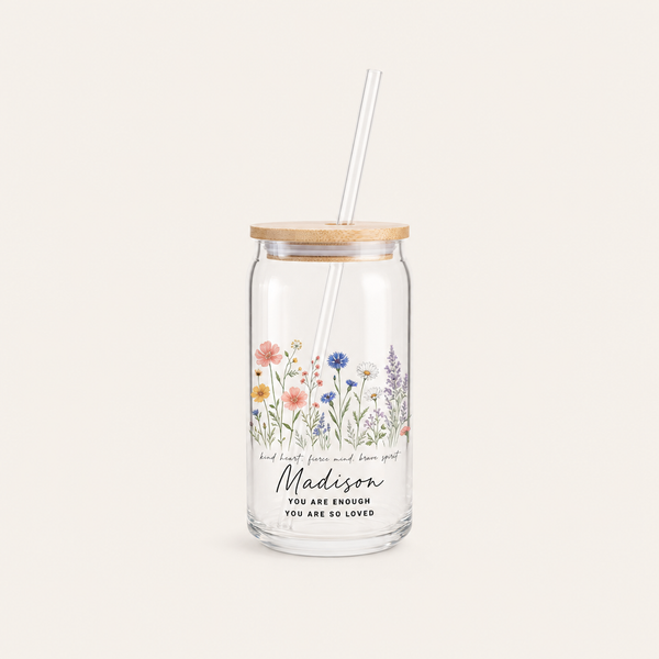 Personalized wildflower glass can with bamboo lid and straw on a cream background