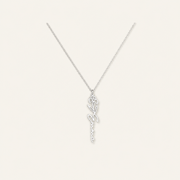 Personalized birth flower name necklace in stainless steel on a cream background